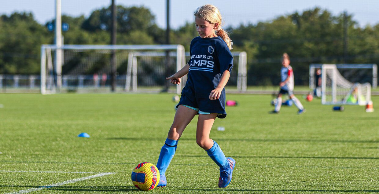 girl kicking a soccer ball at the olathe camp